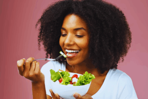Medium shot of a woman enjoying a nutritious salmon bowl, promoting balanced nutrition for optimal ovarian health
