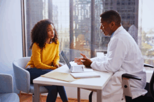 Concerned woman discussing treatment options with a male doctor in a hospital setting, focusing on the possibility of undergoing Endometriosis surgery