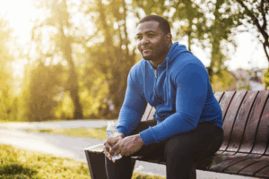 Man resting after exercise and drinking water to support better semen quality and overall reproductive health.