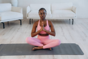 A pretty black woman practicing fertility yoga or meditation to relieve stress and conception anxiety